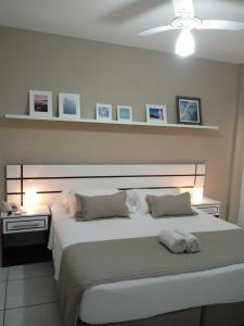 um quarto com uma grande cama branca num quarto em Hotel Marlen em Cabo Frio