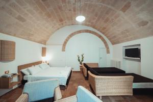 a room with a bed and a couch and chairs at Gradelle San Nicola in Matera