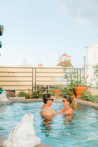 a man and a woman swimming in a pool at Hotel El Convento in San Juan
