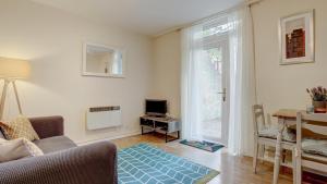 a living room with a couch and a television at Simple City Centre Flat Near River w/ Free Parking in Norwich