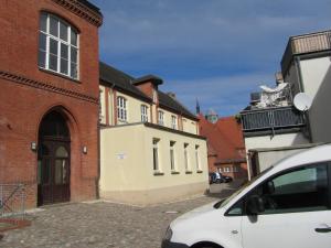 a white car parked in front of a building at Altstadt Ferienwohnung in Wismar +3 photos