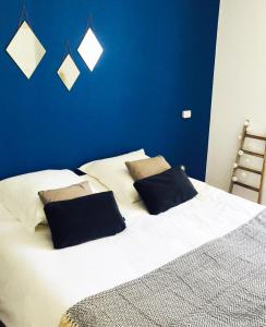 um quarto com uma grande cama branca e 2 almofadas em Le nid de Saint Bedan em Nantes