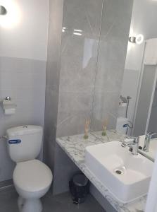 a bathroom with a white toilet and a sink at Parkova - pokoje hotelowe in Gołdap +18 photos