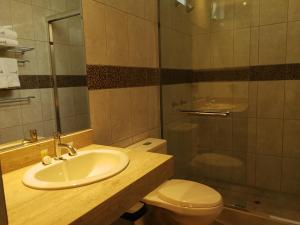 y baño con lavabo, aseo y ducha. en Hotel Inclan, en Lima