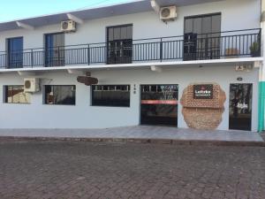 a white building with two balconies on top of it at Pousada Leitzke in Piratini