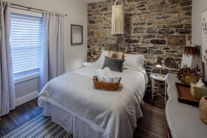 a bedroom with a large bed and a brick wall at The McCrae House - Downtown Kingston in Kingston