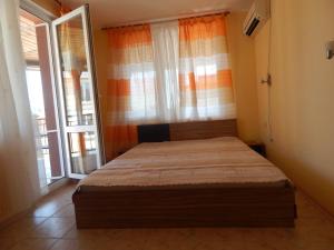 a bedroom with a bed in a room with windows at Dunav Apt.3 in Ravda