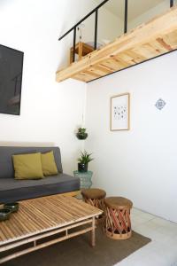 a living room with a couch and two stools at Casa Morelos by Barrio Mexico in Guadalajara