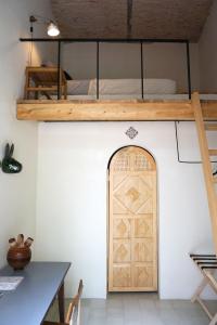 a room with a bunk bed and a wooden door at Casa Morelos by Barrio Mexico in Guadalajara