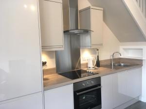 a kitchen with white cabinets and a sink at Haddington George House in Edinburgh