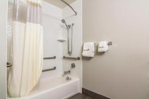 a bathroom with a tub and a shower with a shower curtain at La Quinta by Wyndham Fairbanks Airport in Fairbanks