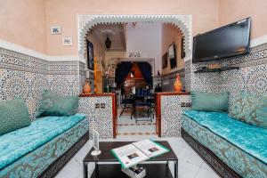 een woonkamer met 2 banken en een tv bij Riad For S in Marrakesh