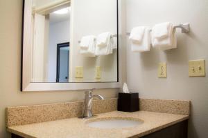a bathroom with a sink and a mirror and towels at La Quinta by Wyndham Fairbanks Airport in Fairbanks