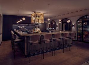 a bar with bar stools in a room at The Anthony Hotel in Utrecht