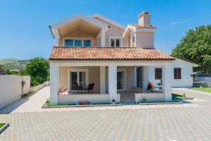 a small white house with a tile roof at Apartmani Nikola 3 in Trogir