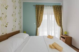 トロギールにあるApartmani Nikola 3のベッドルーム1室(白いベッド1台、タオル2枚付)