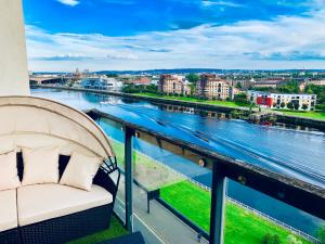 balcón con sofá y vistas al río en Glasgow City Centre - The PENTHOUSE with RiverViews - (Duplex, 3 Bedrooms, 3 Bathrooms, 2 Living rooms/Kitchen, Private SKY Terrace, 2 Parkings, Top Floor, Huge - 2100 sq ft, SECC HYDRO), en Glasgow