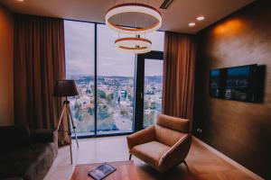 ein Wohnzimmer mit einem Stuhl und einem großen Fenster in der Unterkunft Apartment in King David Residence in Tbilisi City