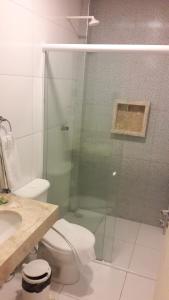 a bathroom with a toilet and a glass shower at Premium Hotel in Mombaça
