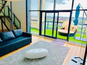 ein Wohnzimmer mit einem Sofa und einem großen Fenster in der Unterkunft Glasgow City Centre - The PENTHOUSE with RiverViews - (Duplex, 3 Bedrooms, 3 Bathrooms, 2 Living rooms/Kitchen, Private SKY Terrace, 2 Parkings, Top Floor, Huge - 2100 sq ft, SECC HYDRO) in Glasgow