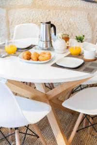 a table with a breakfast of donuts and orange juice at Casa Angelita terraza con hórreo y barbacoa in Poio
