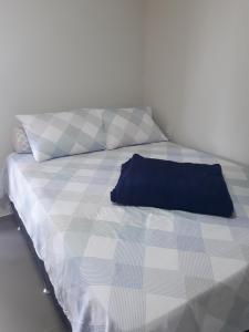 a bed with a blue pillow on top of it at Vivendas da Serra Chalés in Martins