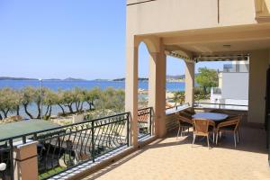 een balkon met een tafel en stoelen en de oceaan bij Apartments Zdenka-10m from beach in Vodice