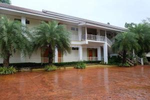 a building with palm trees in front of it at Wangka Resort in Sangkhla Buri