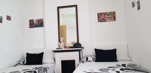 マドリードにあるホスタル ロヨラの鏡付きの部屋のベッド2台