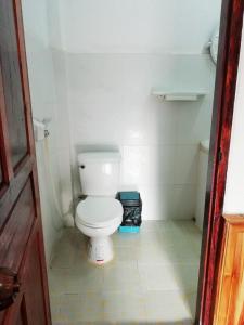 a bathroom with a white toilet in a room at Sunset Bungalows & GH in Ban Ngoy-Nua