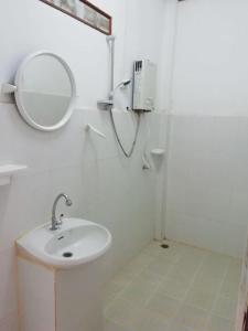 a white bathroom with a sink and a mirror at Sunset Bungalows & GH in Ban Ngoy-Nua