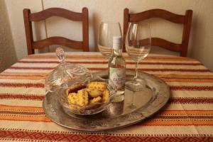 Ein Tisch mit einem Teller, auf dem eine Flasche Wein und Weingläser stehen. in der Unterkunft Casa de Mello in Melo