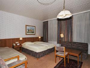 a bedroom with two beds and a desk and a chair at Hotel Bei der Esplanade in Hamburg