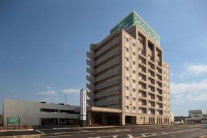 um edifício alto com um sinal em cima em Hotel Route-Inn Toyotajinnaka em Toyota