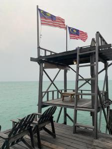 dwie amerykańskie flagi na doku z dwoma krzesłami w obiekcie Spheredivers Scuba & Leisure w mieście Pulau Mabul 