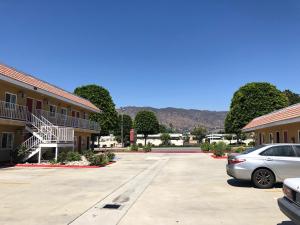 a car parked in a parking lot next to a building at Glendora Motel in Glendora