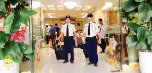 two men in uniform walking through a store at Hoang Yen Canary Hotel in Quy Nhon