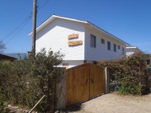 a white house with a wooden fence in front of it at Rapallo´s Los Molles in Los Molles