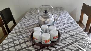 a table with a tea pot and cups on it at Homestay Bukit Dagi Borobudur in Borobudur