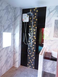 une salle de bain avec douche et lavabo dans l'établissement Blue Andaman Lanta Resort, à Ko Lanta