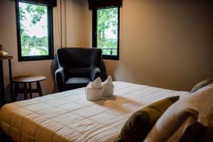 a hotel room with a bed and a chair at Canvas Family Home in Trat