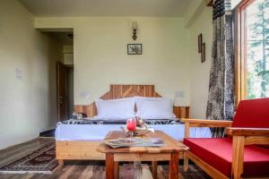 a bedroom with a bed and a table and a couch at Soham's Chateau De Naggar - Manali in Nagar