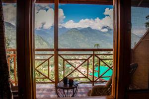 a room with a window with a view of a mountain at Soham's Chateau De Naggar - Manali in Nagar