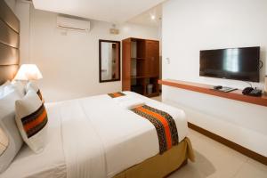a hotel room with two beds and a television at Sur Beach Resort Boracay in Boracay