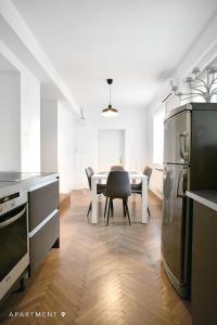 a kitchen with a table, chairs and a refrigerator at Downtown Apartment / Free Parking in Ljubljana