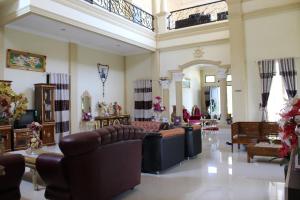 a large living room with couches and chairs at Angela Homestay Manado in Tateli