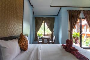 een slaapkamer met een wit bed en een tafel en stoelen bij Chomview Resort in Koh Lanta