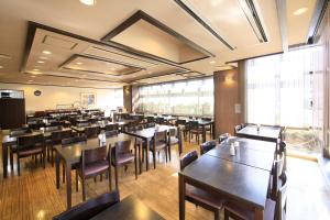 a large dining room with tables and chairs at Maple Inn Makuhari in Chiba