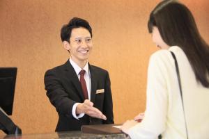 a man in a suit talking to a woman at Maple Inn Makuhari in Chiba