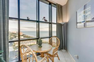 Un comedor con mesa y sillas y una gran ventana. en 2Br Penthouse in the Ocean Forest Plaza, en Myrtle Beach 26 fotos más